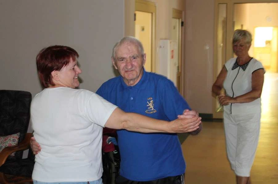 pielęgniarka tańcząca z pacjentem w niebieskiej koszulce